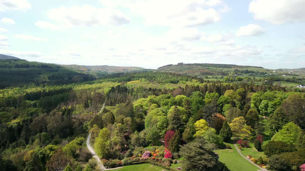 Wide reversing aerial of the Mourne Mountains and Slieve Donard in Newcastle, County Down in Northern Ireland, UK on a bright and sunny day. Filmed in 4K, 60fps and with Rec709 Color.