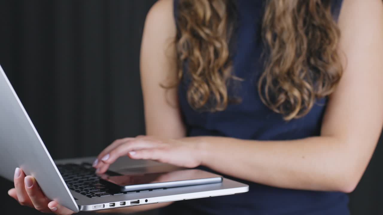 Detailed Close-Up: Woman's Hands Skillfully Navigating Laptop Keyboard Indoors