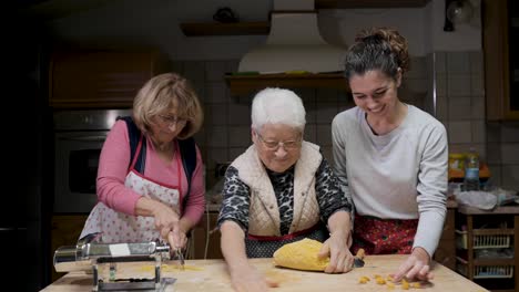 cheerful women cooking tortellini in kitchen together