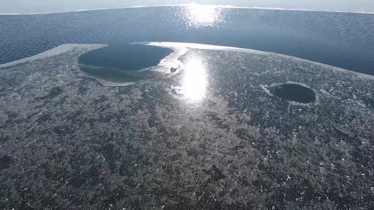 Luftfoto af smeltende is på en frossen sø