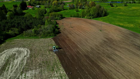 panoramic aerial view of tractor ploughing a fertile agricultural field