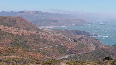 high-altitude view displays the contrast between forested cliffs and the rolling ocean beyond