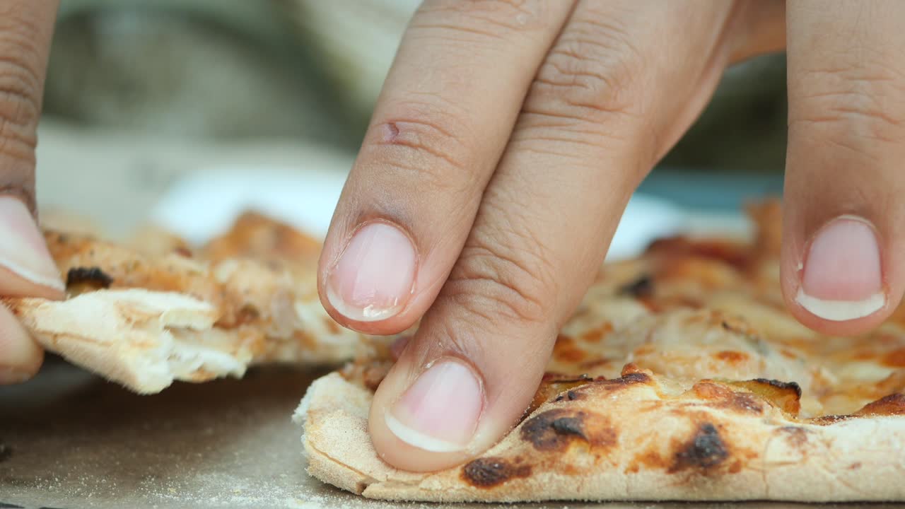 cerca de alguien comiendo una rebanada de pizza