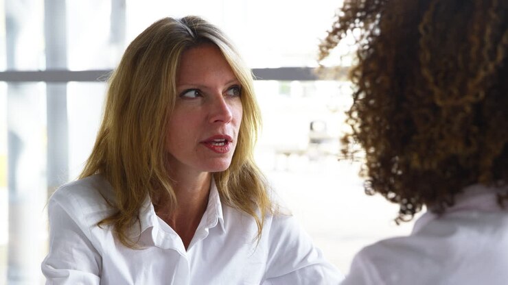 Two Businesswomen Meeting Around Table In Modern Office
