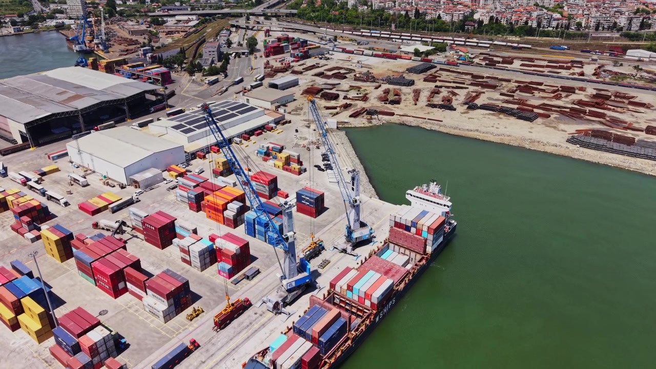 Nave da carico attraccata al porto con molti container durante il giorno.