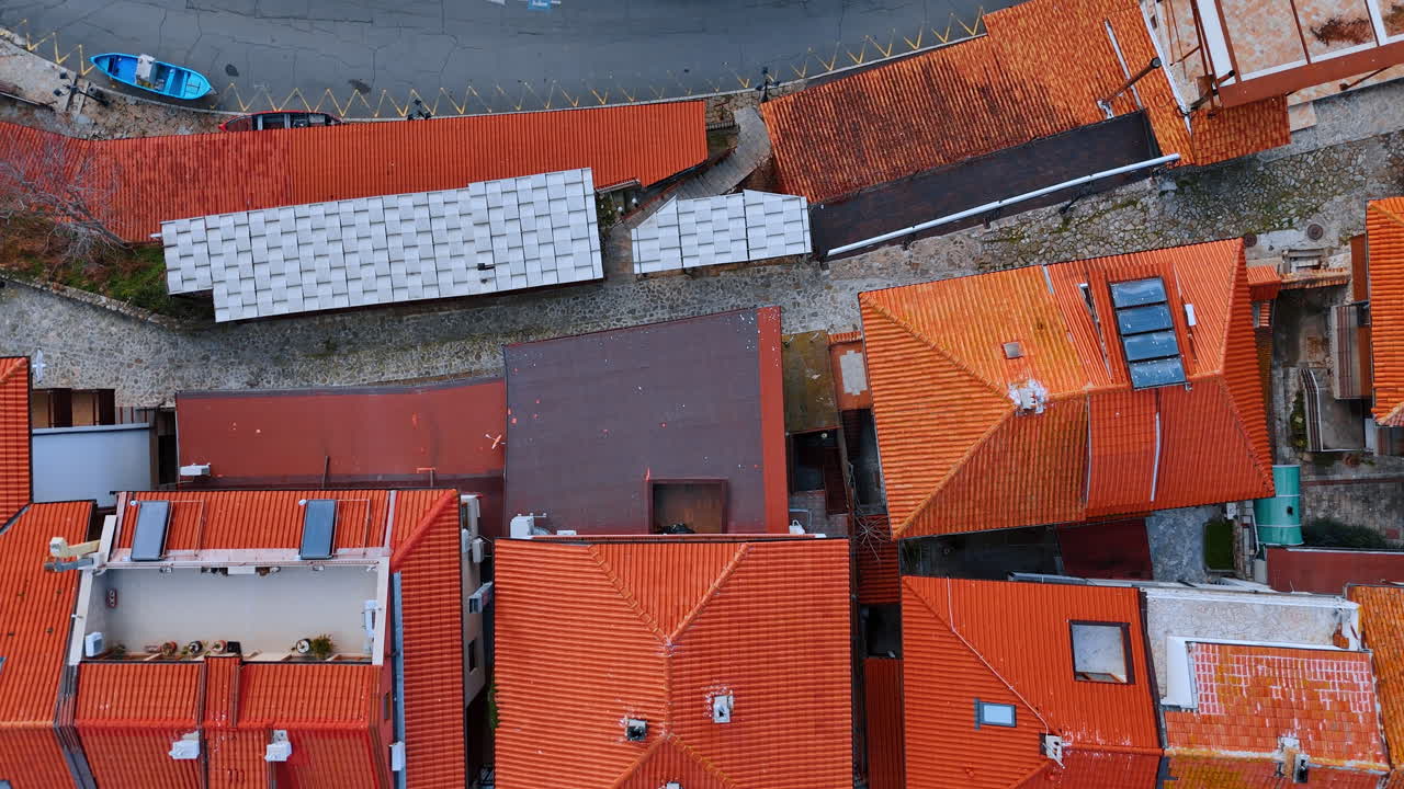 Veduta aerea dall'alto di tetti in tegole rosse. Prospettiva aerea di edifici urbani e auto parcheggiate in strada.
