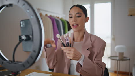 blogger de belleza recomendando pinceles para grabar teléfono inteligente. blog de filmación de mujeres