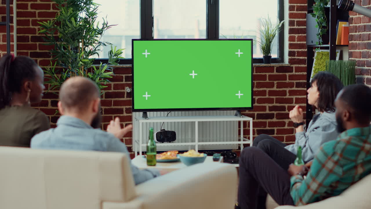 Diverse people watching movie on television with greenscreen
