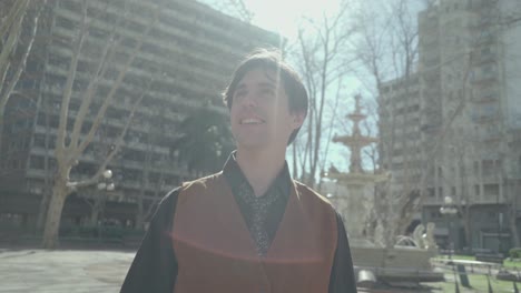 arc shot of young business man looking at the sky and nodding in a public square 4k shot