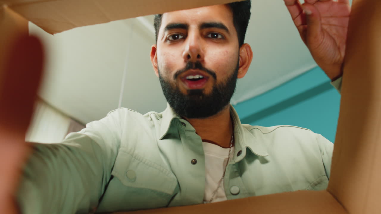 hombre indio feliz comprador desempaquetando caja de cartón entrega paquete compras en línea compra en casa