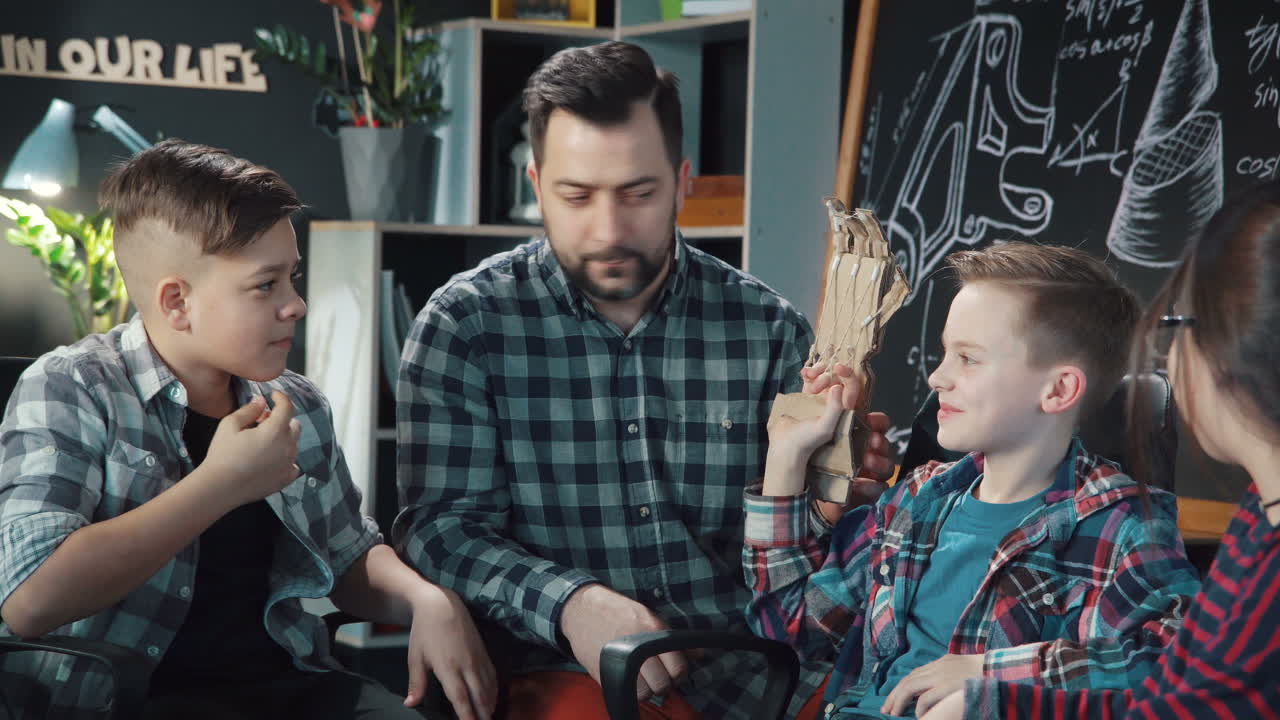 estudiantes que colaboran con un maestro en un proyecto