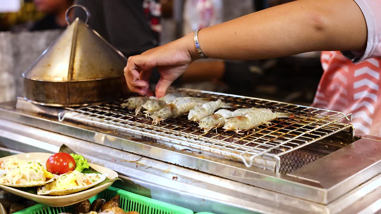 proceso de parrillaje de mariscos en un bullicioso mercado nocturno