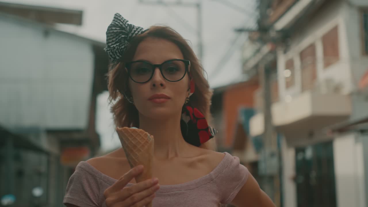Donna elegante si gusta un gelato in una via cittadina.