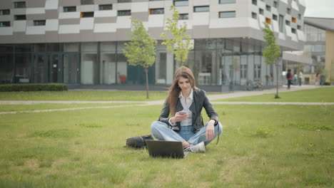 happy young beautiful woman in stylish clothes texting message on smartphone on city street portrait