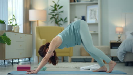 woman practicing downward-facing dog yoga pose at home