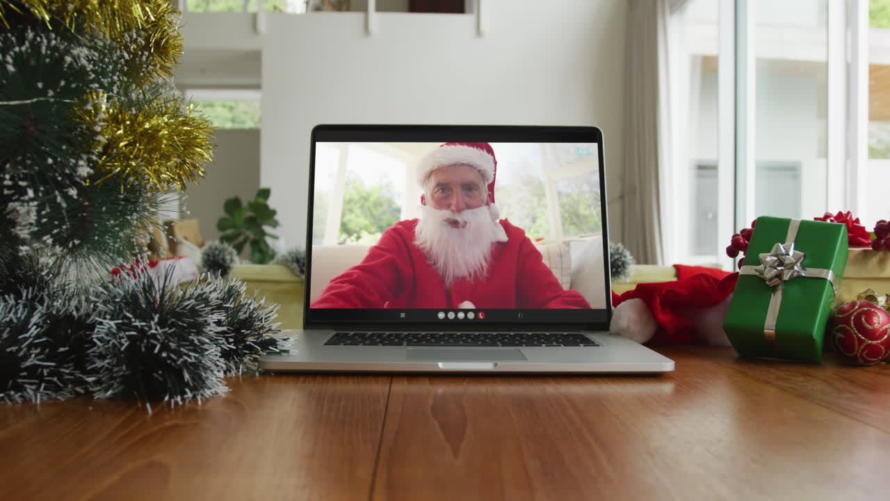 hombre caucásico con disfraz de santa en una videollamada de navidad en una computadora portátil