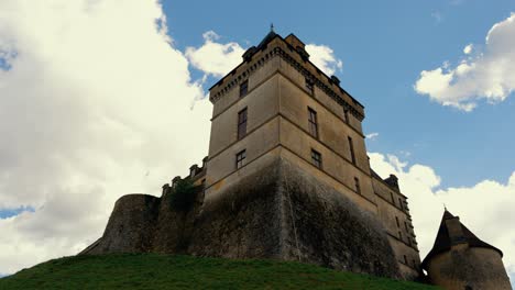 Time-lapse-of-the-Biron-castel,-a-cliff-side-chateau-in-the-Dordogne-region-near-Monpazier-village,-clouds-pass-behind-the-building,-light-gradually-illuminates-the-stones-of-the-building,-France