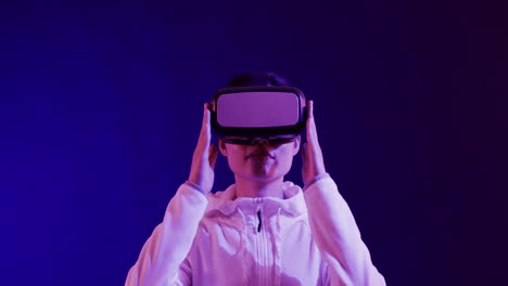 asian woman using vr headset on blue background, copy space, slow motion