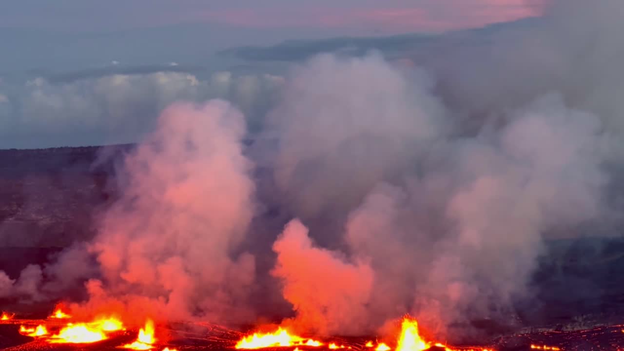 Cinematic long lens booming down shot of the glowing lava lake at Kilauea as the volcano erupts at sunset on the first day of activity in September 2023 on the island of Hawai'i