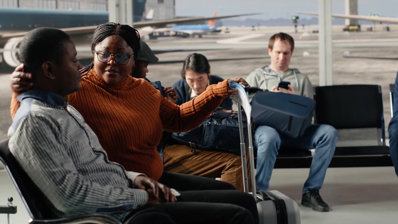 Checking flight status information, screen and diverse tourists with trolleys