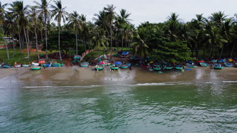 panning view over a coloured beach full with little boats