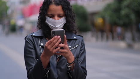 woman on phone checking latest government updates wearing mask in city during covid19 outbreak and lockdown-1