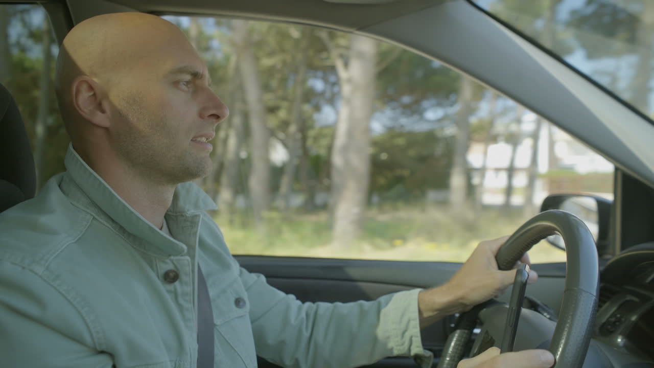 hombre con un teléfono inteligente y conduciendo un coche