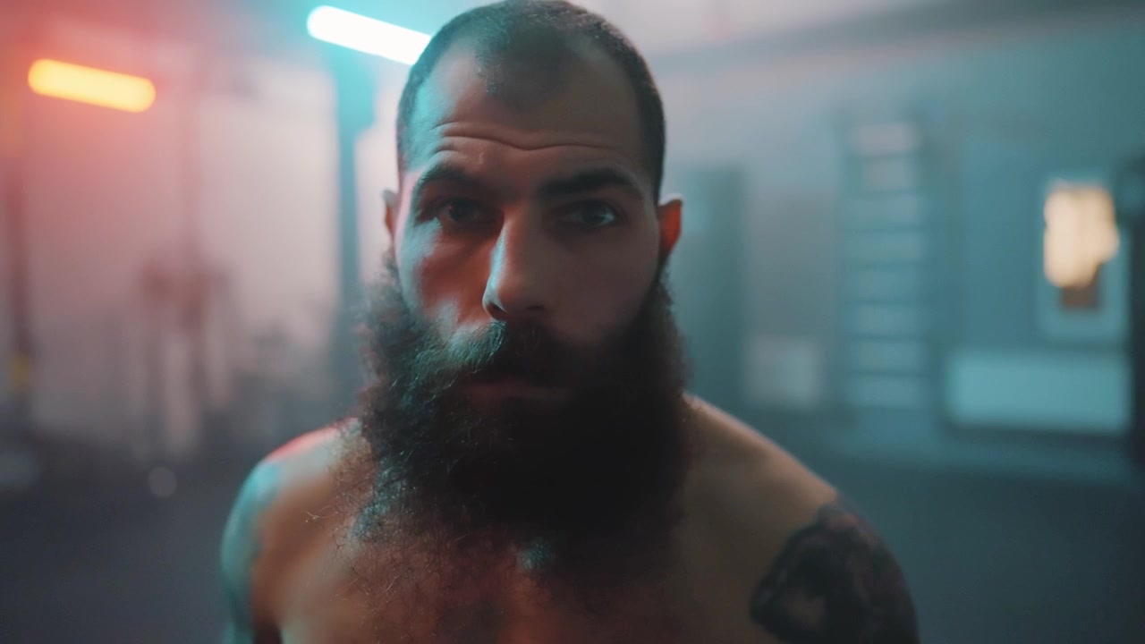 Ritratto ravvicinato di un uomo barbuto serio in una palestra.