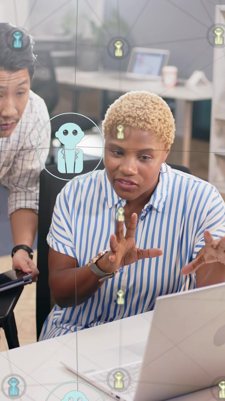 Vertical video: Business woman working on laptop as man leaning, pointing, avatar icons marking her