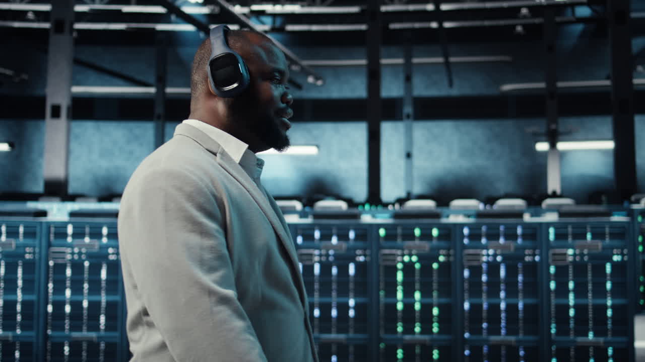 Vertical video Happy worker wearing headphones walking in data center