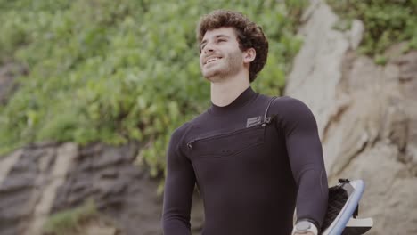 young surfer in a wetsuit holding a surfboard