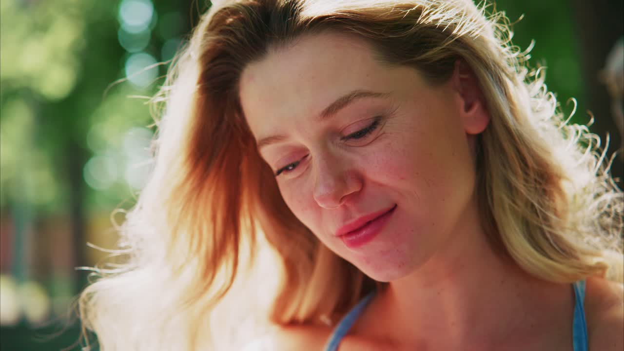 Happy Young Blonde Woman Smiling Outdoors in Sunlight