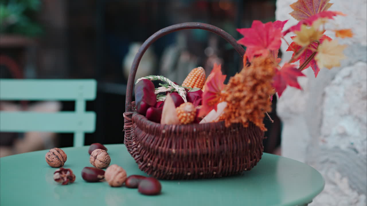 Un cesto pieno di decorazioni a tema autunnale su un tavolo in terrazza