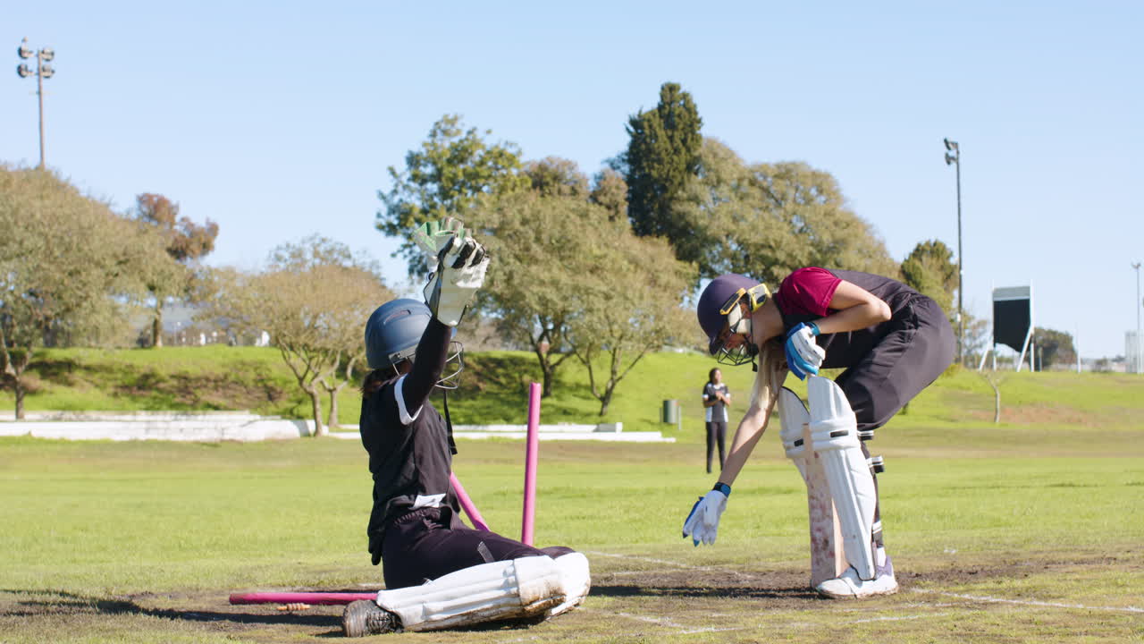 Playing cricket, female players running between wickets on sunny day