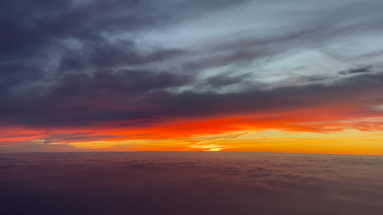 태양이 떠오르는 성경적인 하늘을 날아다니는 비행기의 조종석에서 볼 수 있는 인상적인 불빛 해가 뜨는 모습, 구름 아래와 바다 위를 날아다닙니다.