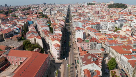 Vista-Aérea-De-Drones-De-Una-Calle-Larga-Y-Recta-En-La-Ciudad.-La-Cámara-Se-Inclina-Hacia-Abajo-Y-Se-Acerca-A-La-Casa-En-La-Esquina-De-Una-Calle-Afilada.-Lisboa,-Capital-De-Portugal.