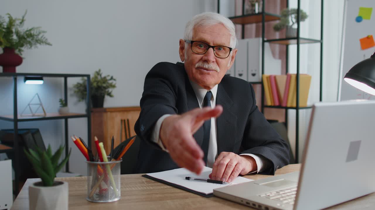 Senior business man employee outstretching hand to camera offering handshake greeting welcoming