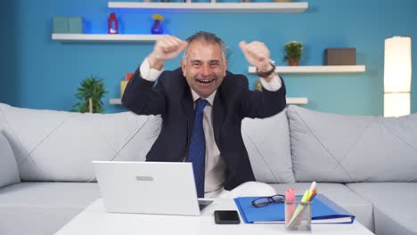 home office worker man experiencing joy looking at camera.