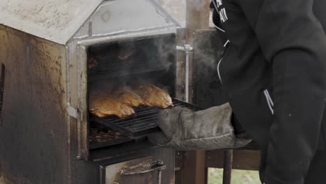 Taking-delicious-mouth-watering-smelling-meal-out-of-backyard-oven-with-steam