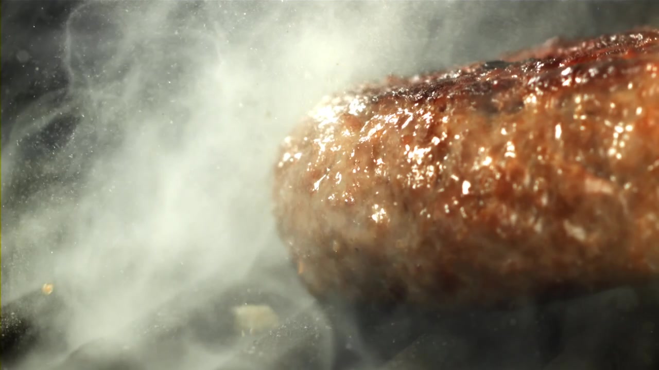 Lækker pølse steger på en grill med opstigende røg