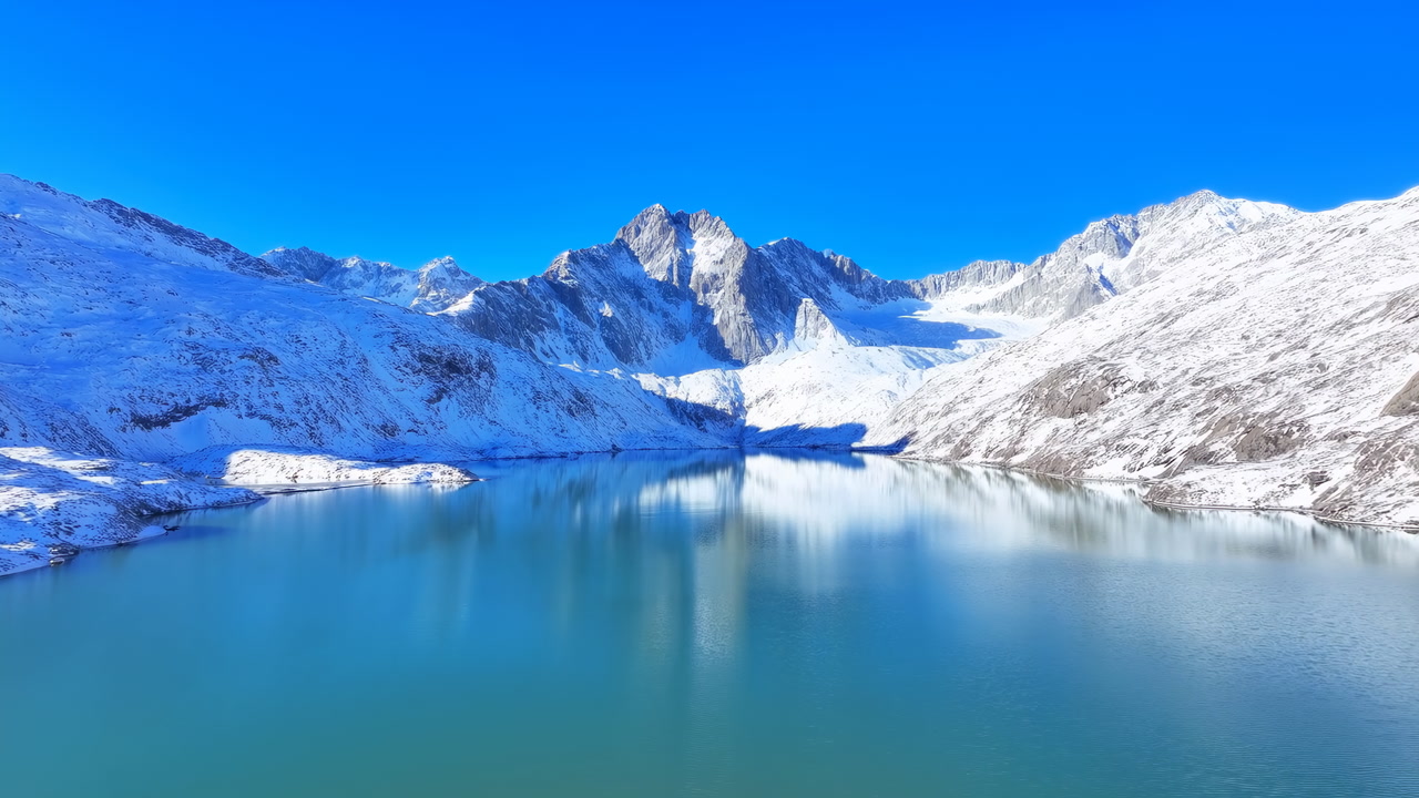 Snowy Mountain Lake Under Blue Sky, Pristine Turquoise Water Reflecting Jagged Glacier Peaks, Crisp Sunlight