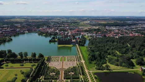 aerial view over an opulent garden and the frederiksborg castle in hillerod denmark - drone pullback