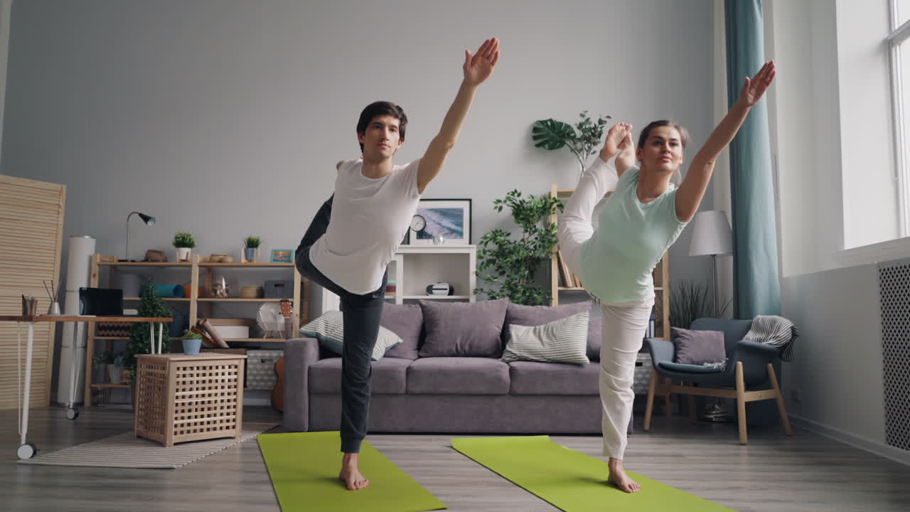 pareja practicando yoga en casa