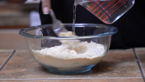 mixing and stirring water into a dry, organic kamut flour mix with a fork - isolated close up