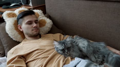 young man with his light gray fluffy cat