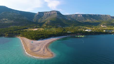 -Panorama-of-a-coastal-town-,-surrounded-by-the-sea-and-mountains-under-blue-sky-with-white-clouds