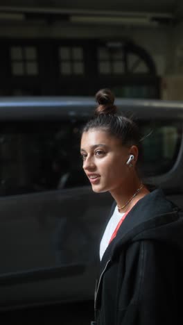 young woman wearing earpods on the street