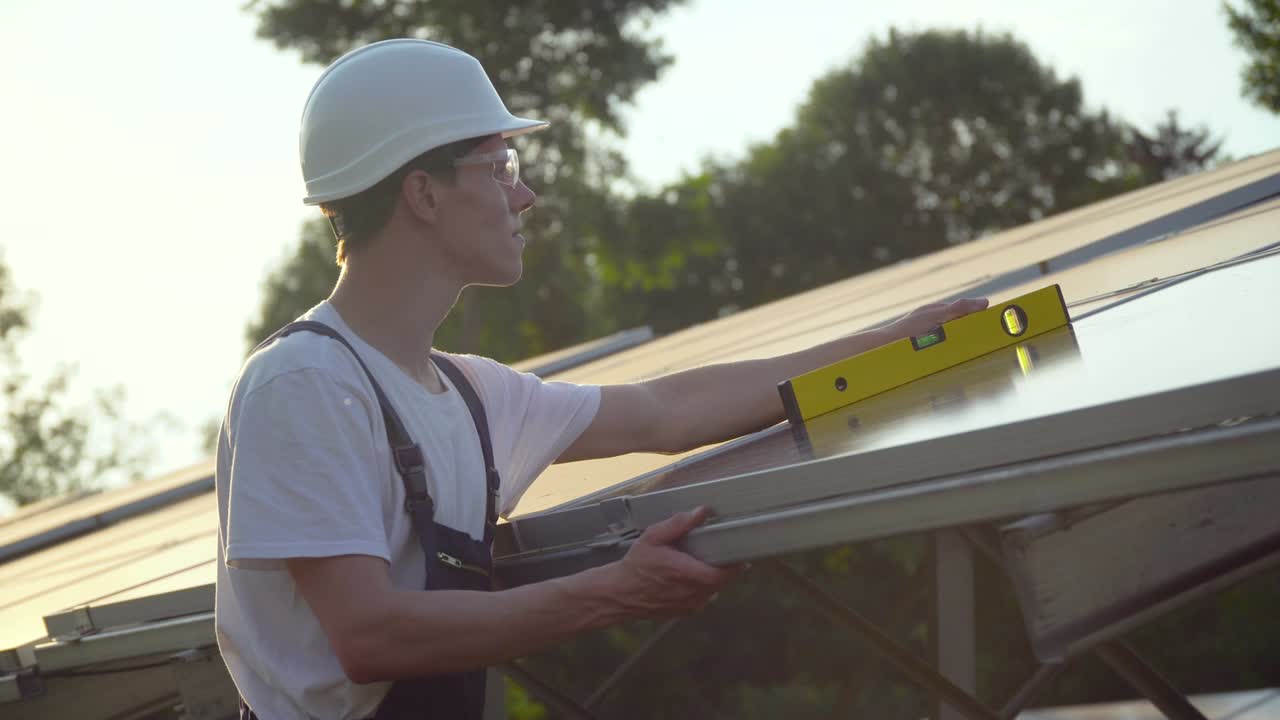 Young enginneer installing new sunny batteries. The green energy concept