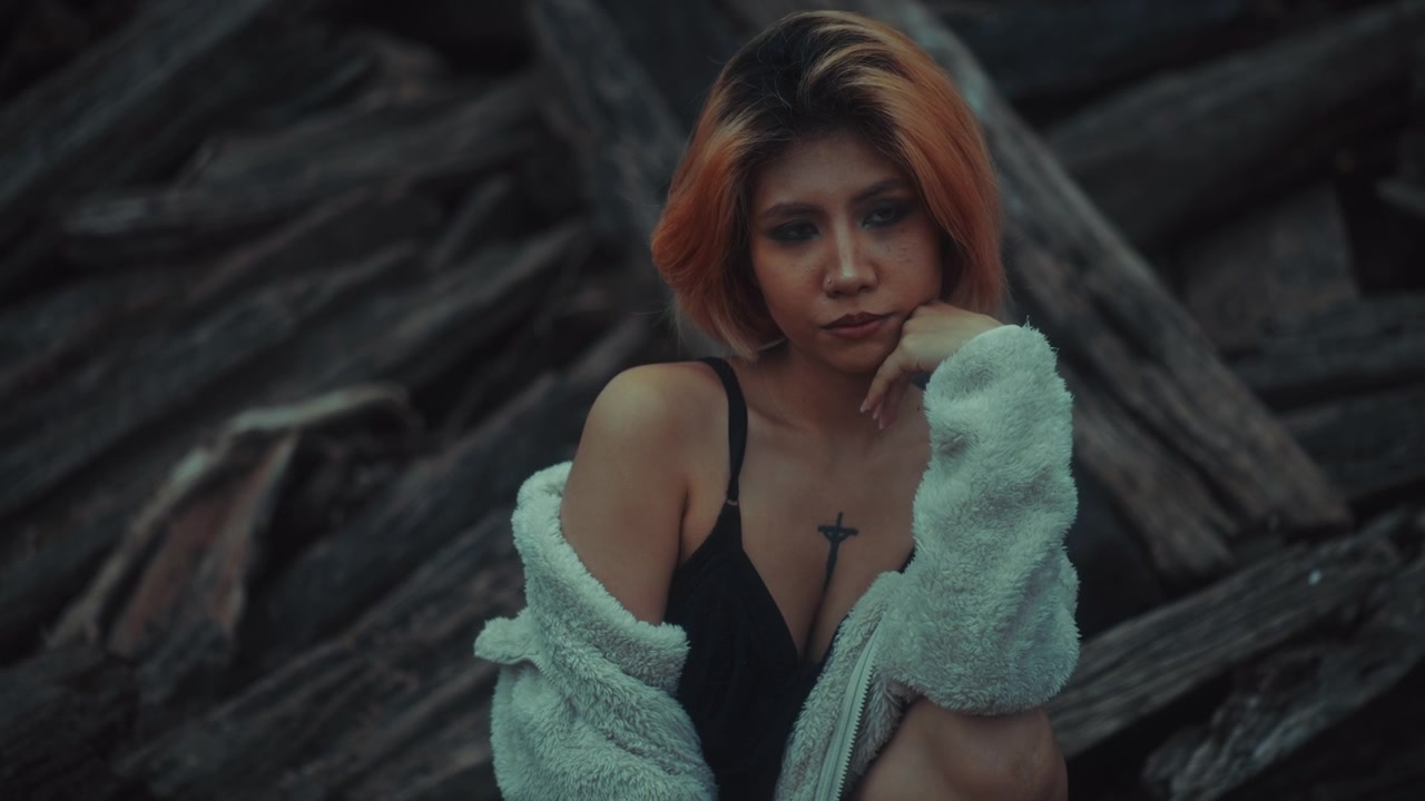 Thoughtful Young Asian Woman with Short Hair and Tattoos