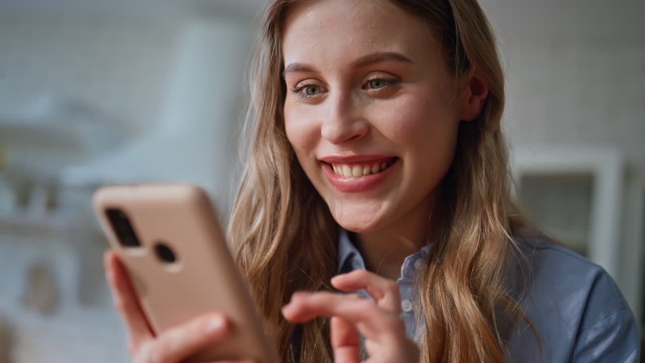 Woman hands touching mobile phone screen at kitchen closeup. Lady rejoicing